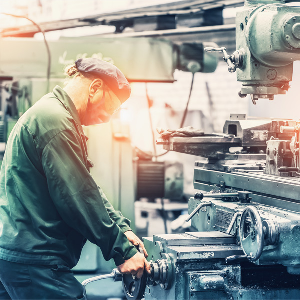 Worker running milling machine - manufacturing shop